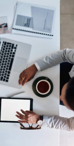 50986566_shes-connected-on-all-fronts-high-angle-shot-of-a-young-businesswoman-using-a-laptop-and-digital-tablet-while-working-in-her-office